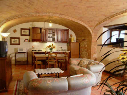 Saloncino dell'appartamento Girasoli con visuale sullu cucina sotto l'arco toscano ellissoide